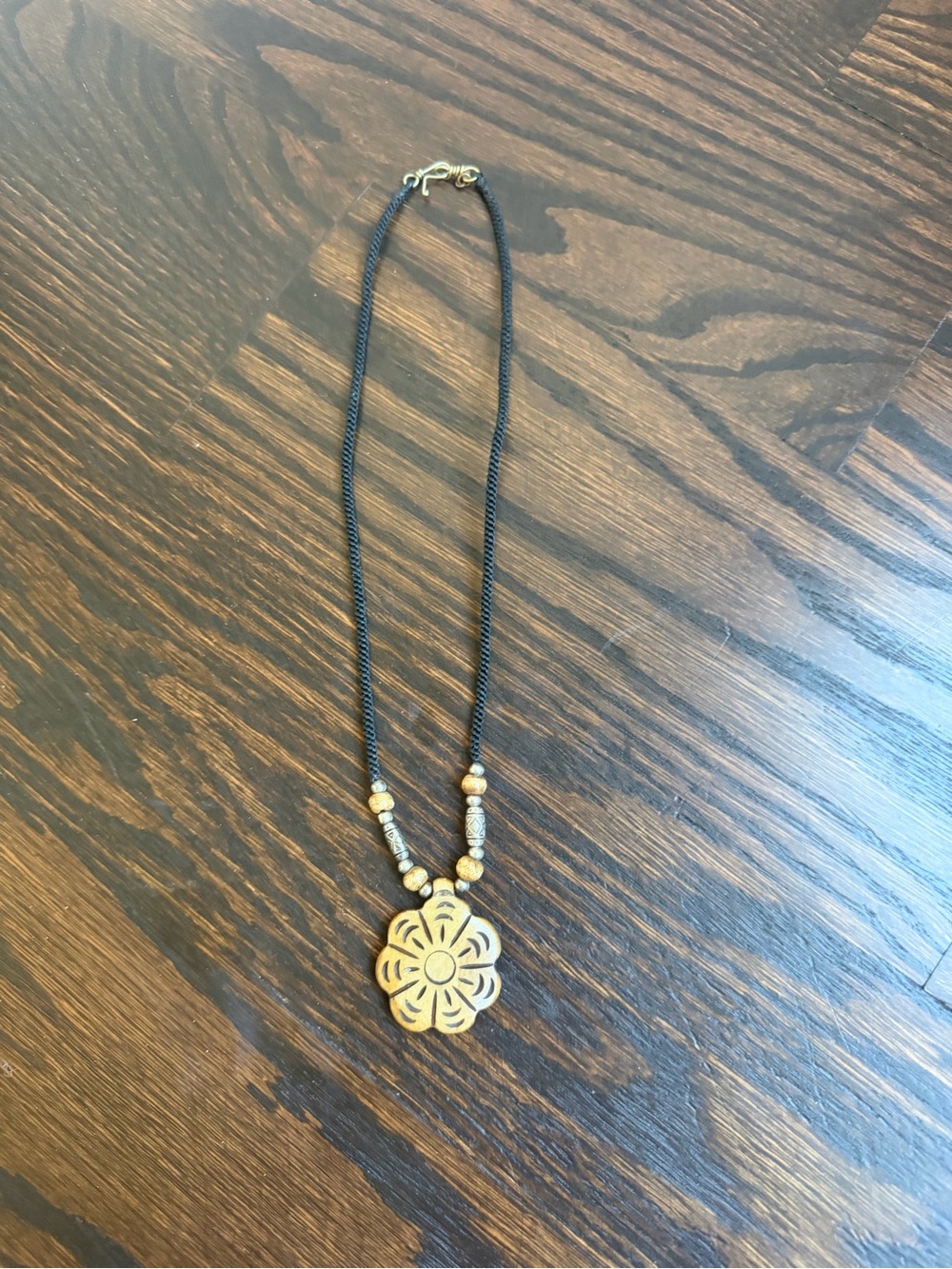Guardian cord necklace featuring a distinct, intricately carved floral pendant